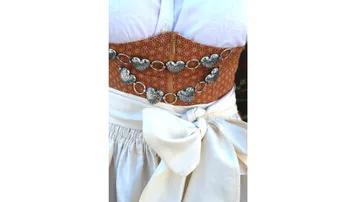 Corsage mit Herz-Gürtel trägt eine weiße Schürze.