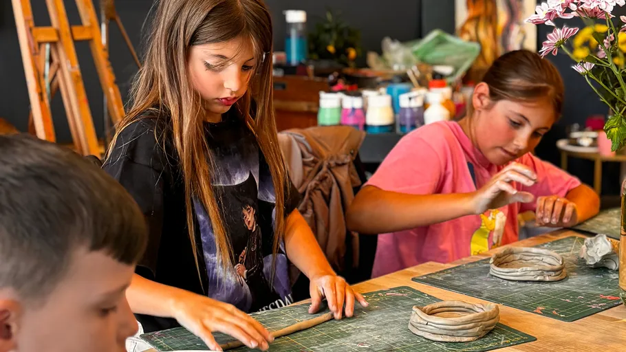 Children crafting clay in art class.