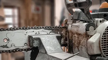 Chainsaw stands still in a workshop environment.