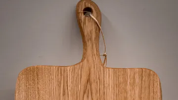 Holzbrett hängt an einer Wand, bereit zur Verwendung.
