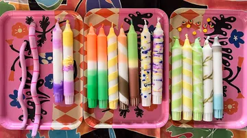Bunte Kerzen auf zwei Platten, kreativ arrangiert.