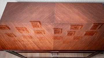 Holztisch reflektiert Licht von Bildern in der Umgebung.