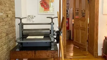 Druckmaschine steht in einem hellen, gestalteten Raum.