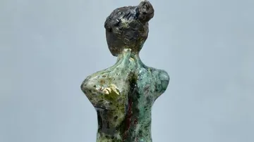 Eine Skulptur zeigt eine stehende, verwundene weibliche Figur.