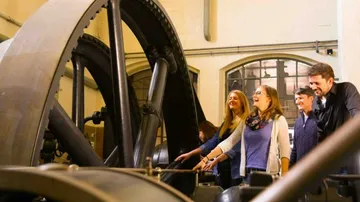 A big machine surrounded by smiling people.