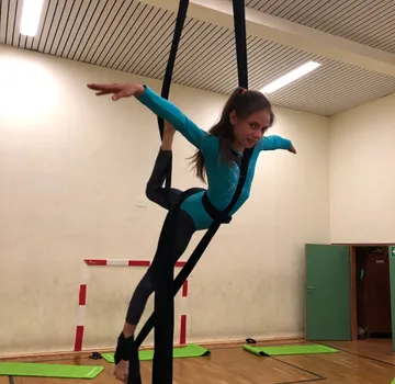 Girl is swinging with a towel in a practice room.