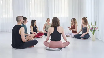 Group of people sit in a circle and discuss in a relaxed manner.