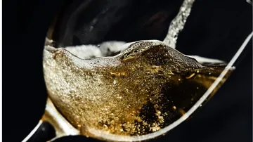 A glass of sparkling drink that overflows.