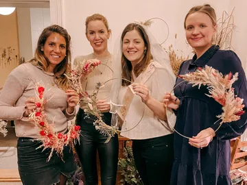 Four women are holding handicrafts with dried flowers.
