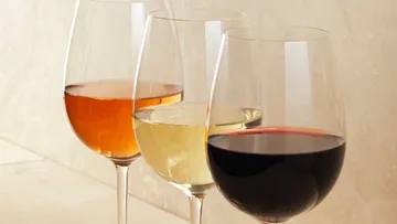 Drei Weingläser stehen nebeneinander mit unterschiedlichen Weinsorten.