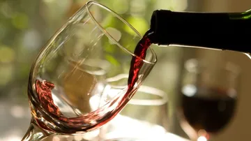 Red wine is poured from a bottle into a glass.