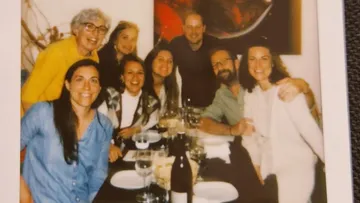 Gruppe von Freunden genießt ein Abendessen an einem Tisch.
