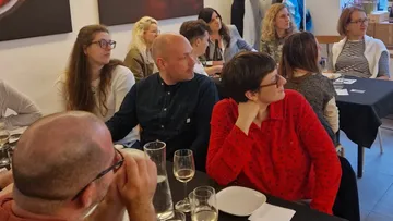 Gruppe von Menschen blickt aufmerksam in ein Restaurant.