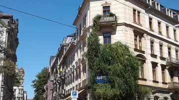 Helles Gebäude mit Pflanzen, ruhig in der Stadt.