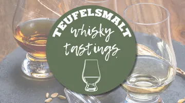 Gläser mit Whisky stehen auf einem Tisch; Beschriftung sichtbar.