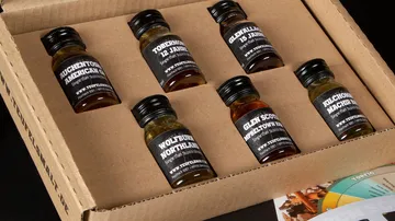 Six small bottles of whiskey in cardboard packaging.