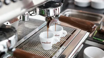 Espressomaschine brüht Kaffee in zwei Tassen im Café.