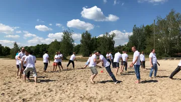 Menschen spielen im Sand, während sie Spaß im Freien haben.