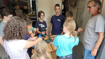Gruppe von Kindern arbeitet an einem Tisch mit Werkzeug