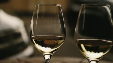 There are two wine glasses on a table.