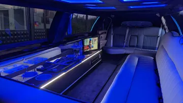 Luxury limousine with blue lights and television.