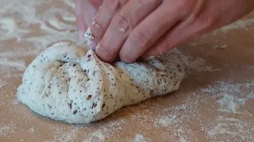 Dough is kneaded on a floured surface.