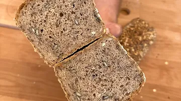 A piece of bread is cut open and shows the crumb.