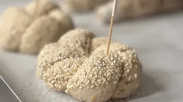 Sesame rolls are prepared on a tray.