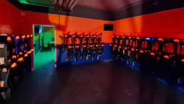 Raum mit leuchtenden Lasertag-Ausrüstungen an den Wänden.