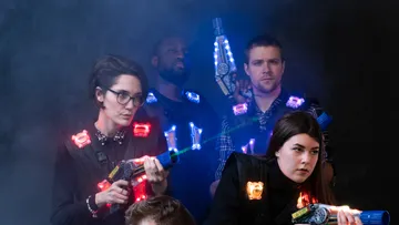 Four people keep futuristic toy weapons in smoke.