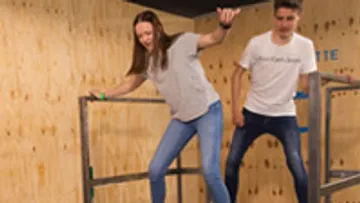 Woman balancing on a structure in a room.