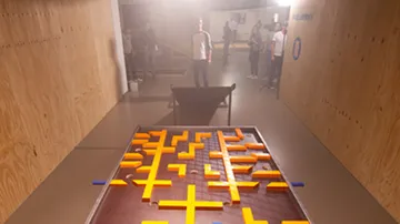 There is a game board with orange building blocks in the room.