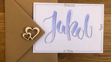 Card with the name “Jakob” and heart pattern, is in an envelope.