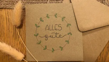Card with the words “Alles Gute” surrounded by plants