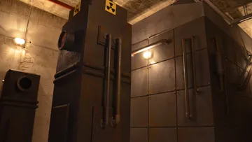 Dark industrial machines with warning symbols are on the wall.