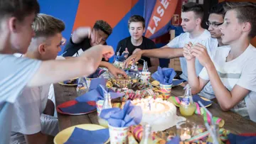 Celebrating young people grab snacks at a birthday party.