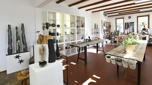 Kunsthandwerksgeschäft mit Skulpturen und Holzarbeiten, hell erleuchtet.