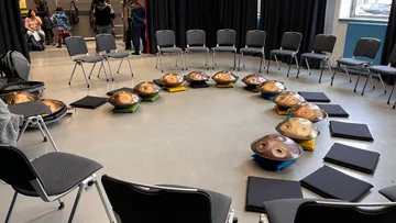 Runde Sitze mit Handpan-Instrumenten in einem Raum.