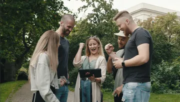 Gruppierung von Freunden, die gemeinsam auf ein Tablet schauen.