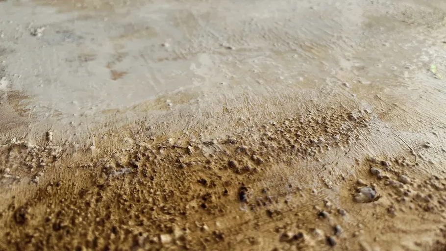 Rough surface structure with brown and grey hues.