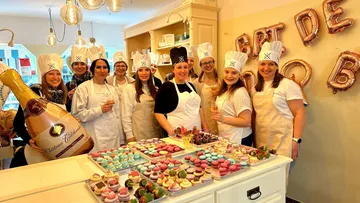 Bäckerinnen lächeln, während sie Desserts in einem Kurs präsentieren.