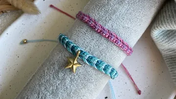 Two colorful bracelets rest on a soft surface.