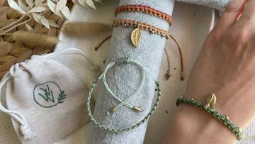 Wristbands lie on gray cloth with hands next to them.
