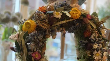 Blumenkranz schmückt einen Raum mit bunten, getrockneten Pflanzen.