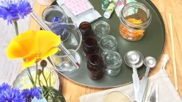 Colorful flowers and glass containers arranged on a tray.