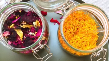 Two glasses of dried flowers on a tray.