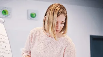 Woman looking at a flip chart in a modern room.