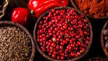 Colourful spices in bowls, together on a table.