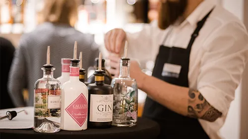 Bottles of spirits are prepared at a table.