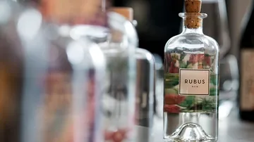 Decorative bottle with label surrounded by other bottles